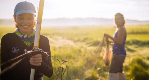 Two female students conducting research in salt water marsh